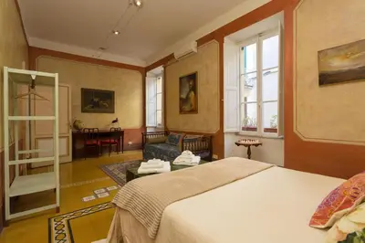 a bedroom with a bed and a living room at Domus Picta Roomy Apartment in Rome