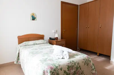a bedroom with a bed with two towels on it at Villa Santa Emerenziana in Rome