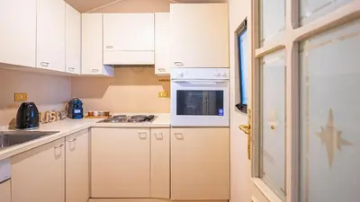 a kitchen with white cabinets and a stove top oven at EasyTopStay - Charme and View in the Heart of Rome in Rome