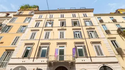 a large yellow building with windows and a balcony at EasyTopStay - Charme and View in the Heart of Rome in Rome