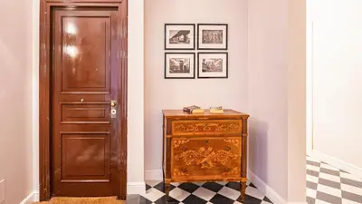 a hallway with a wooden door and a dresser in a room at EasyTopStay - Charme and View in the Heart of Rome in Rome
