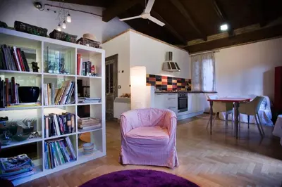 a living room with a pink chair and a table at Monolocale Centro Stazione Tiburtina in Rome