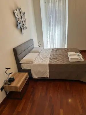 a bedroom with a large bed and a wooden floor at 3 coins trastevere station in Rome