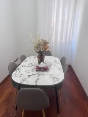 a dining room table with a vase of flowers on it at 3 coins trastevere station in Rome