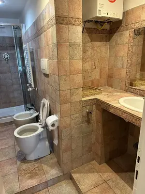 a bathroom with a toilet and a shower and a sink at 3 coins trastevere station in Rome