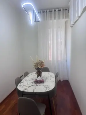 a dining room table with a vase of flowers on it at 3 coins trastevere station in Rome