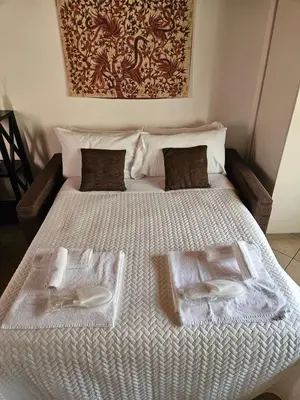 a white bed with two towels on top of it at Monolocale loft ristrutturato- Metro Manzoni in Rome