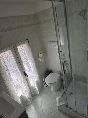 a bathroom with a toilet and a glass shower at Monolocale loft ristrutturato- Metro Manzoni in Rome