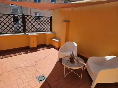a balcony with two chairs and a table and a fence at Monolocale loft ristrutturato- Metro Manzoni in Rome