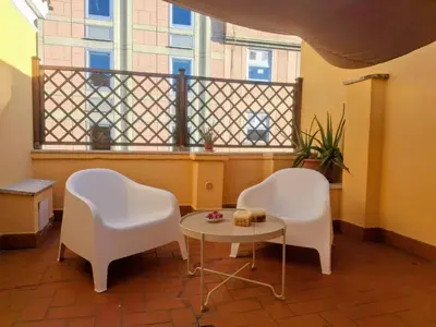 two chairs and a table in a room with a balcony at Monolocale loft ristrutturato- Metro Manzoni in Rome