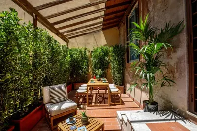a patio with a table and chairs and plants at Daplace - Serena Apartment in Rome