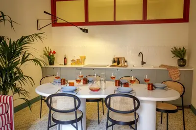 two tables in a kitchen with chairs and a sink at Daplace - Serena Apartment in Rome