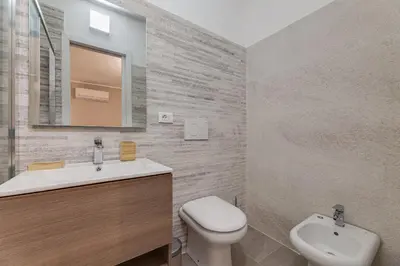 a bathroom with a sink and a toilet and a mirror at Vogue Suites Rome in Rome