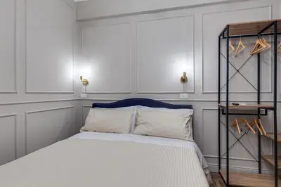 a bedroom with a white bed with a blue headboard at Vogue Suites Rome in Rome