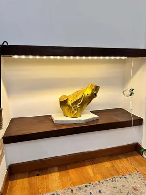 a gold sculpture on a wooden shelf with lights at Villa Classical Roman Art - Monteverde with Garden in Rome