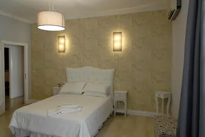 a bedroom with a white bed and a wall at B&B Tiburtina Garden in Rome