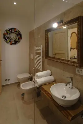 a bathroom with a sink and a toilet and a mirror at B&B Tiburtina Garden in Rome