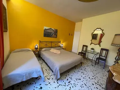 a bedroom with two beds and a yellow wall at B&B Tiburtina Garden in Rome