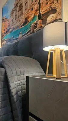 a room with a bed and a table with a lamp at Casa Camillo in Rome