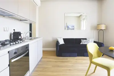 a kitchen and living room with a table and a couch at Easylife - Charme, comfort e quiete vicino Termini in Rome