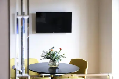 a dining room table with a vase of flowers on it at Easylife - Charme, comfort e quiete vicino Termini in Rome