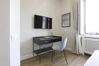 a black desk with a chair and a tv on a wall at Easylife - Charme, comfort e quiete vicino Termini in Rome