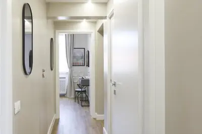 a hallway with white walls and a mirror and a table at Easylife - Charme, comfort e quiete vicino Termini in Rome