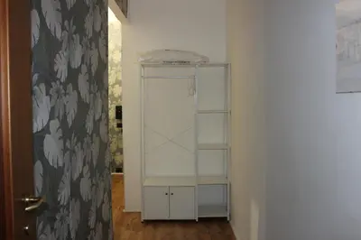 a white shelf in a room next to a door at Rooms Piramide 1 in Rome