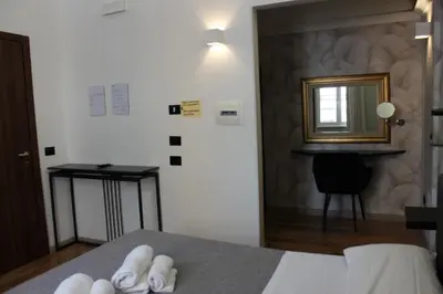 a room with a bed with a mirror and a table at Rooms Piramide 1 in Rome