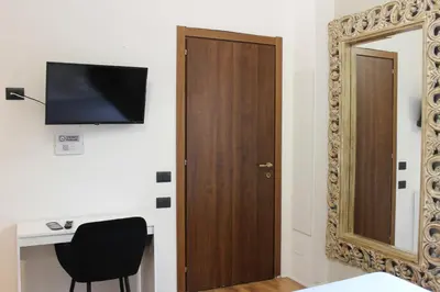a room with a door and a chair and a mirror at Rooms Piramide 1 in Rome
