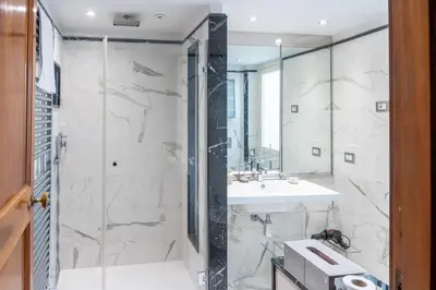 a bathroom with a shower and a sink and a mirror at Roman Charme Spagna in Rome