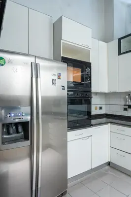 a kitchen with a stainless steel refrigerator and microwave at Roman Charme Spagna in Rome
