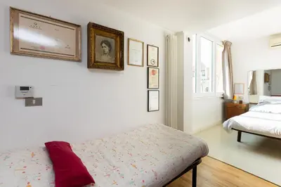 a white bedroom with a bed and a window at Borgo Vittorio Terrace by Rental in Rome in Rome