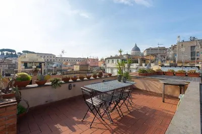 a patio with a table and chairs on a balcony at Borgo Vittorio Terrace by Rental in Rome in Rome
