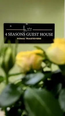 a sign that reads seasons guest house with yellow roses at 4 Seasons Roma Trastevere in Rome