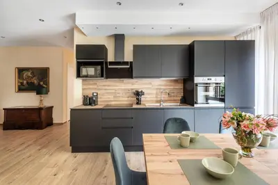 a kitchen with black cabinets and a wooden table at ROMAN DREAM lll in Rome