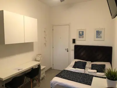 a bedroom with a bed and a desk in it at Rhome Lungotevere River in Rome