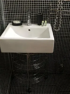 a white sink in a black tiled bathroom at Rhome Lungotevere River in Rome
