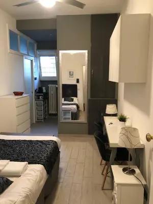 a bedroom with a bed and a desk and a mirror at Rhome Lungotevere River in Rome