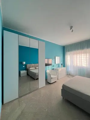 a bedroom with blue walls and a bed and a mirror at F R Vatican view apartment in Rome