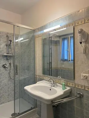 a bathroom with a sink and a glass shower at F R Vatican view apartment in Rome