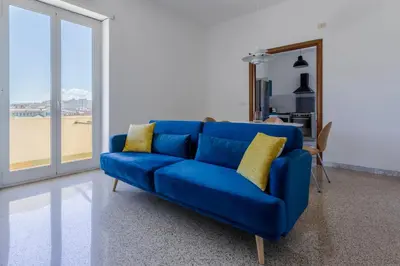 a blue couch with yellow pillows in a living room at GuestHost - Re di Roma - Bright Apartment X4 in Rome