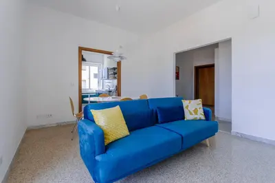 a blue couch in a living room with a mirror at GuestHost - Re di Roma - Bright Apartment X4 in Rome