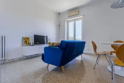 a blue chair in a living room with a tv at GuestHost - Re di Roma - Bright Apartment X4 in Rome
