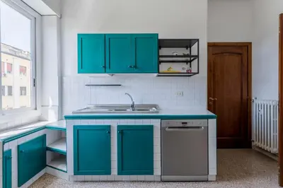 a kitchen with blue cabinets and a sink at GuestHost - Re di Roma - Bright Apartment X4 in Rome