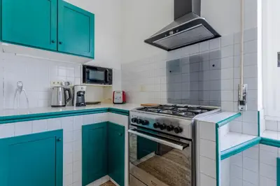 a kitchen with blue cabinets and a stove at GuestHost - Re di Roma - Bright Apartment X4 in Rome