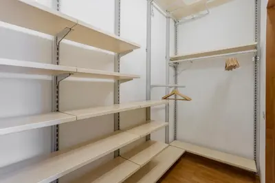 a walk in closet with wooden shelves at GuestHost - Re di Roma - Bright Apartment X4 in Rome
