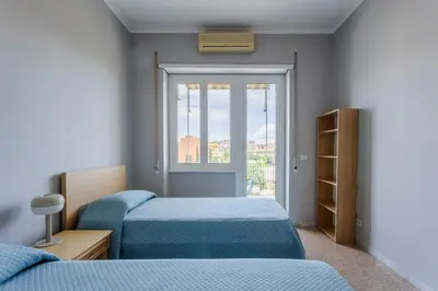 a bedroom with two beds and a window at GuestHost - Re di Roma - Bright Apartment X4 in Rome