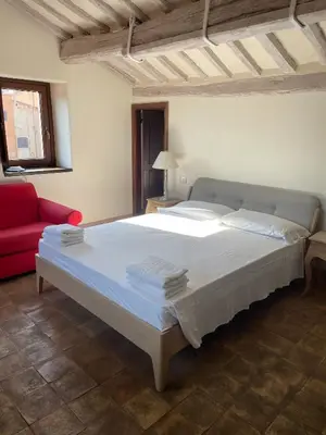 a bedroom with a large bed and a red couch at Laurina F1 Studio with Panoramic Terrace - LOCAPPART in Rome