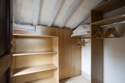 a closet with wooden shelves and a ceiling at Laurina F1 Studio with Panoramic Terrace - LOCAPPART in Rome